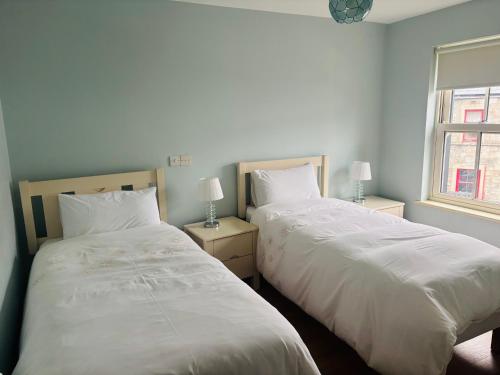 two beds sitting next to each other in a bedroom at Town Apartment in Ardara