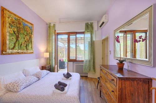 a bedroom with a bed and a dresser and a window at Casamia Tuscan Oasis 4Br Panoramic Penthouse Hot Tub & Easy Parking in Siena
