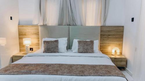 a bedroom with a large white bed with two pillows at French quarters apartments in Alaguntan