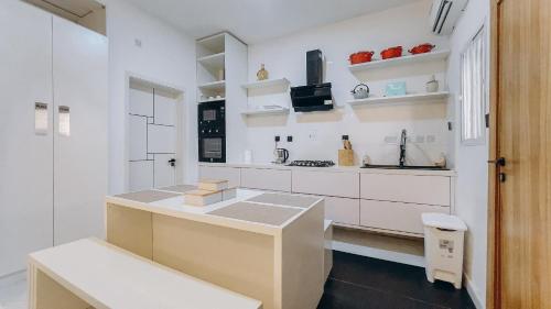 a white kitchen with white cabinets and a counter at French quarters apartments in Alaguntan