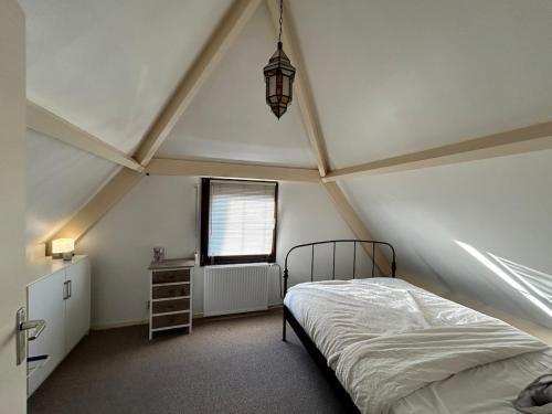 a bedroom with a bed and a window at Het schapenhuisje in Herkingen