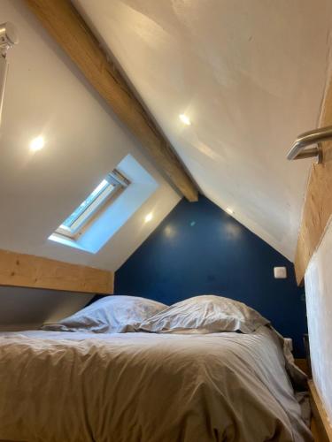 a bedroom with a bed with a blue wall at La villa dans les pins in Quend