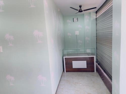 a room with a desk with palm trees on the wall at Hotel Paradise in Rewa