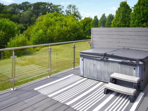 a wooden deck with a barbecue grill and a bench at Oak Park One - Uk50062 in Tiverton