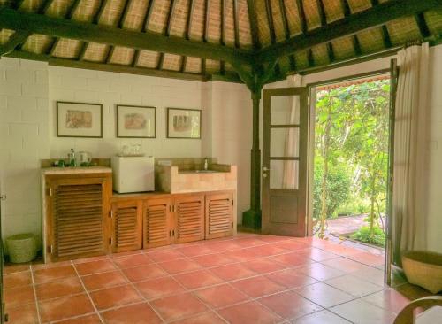 a kitchen with an open door to a patio at Bukit Asri Lodge in Seraya