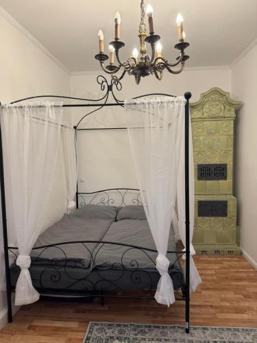 ein Schlafzimmer mit einem schwarzen Himmelbett mit Kronleuchter in der Unterkunft Maxplatz in Rehau