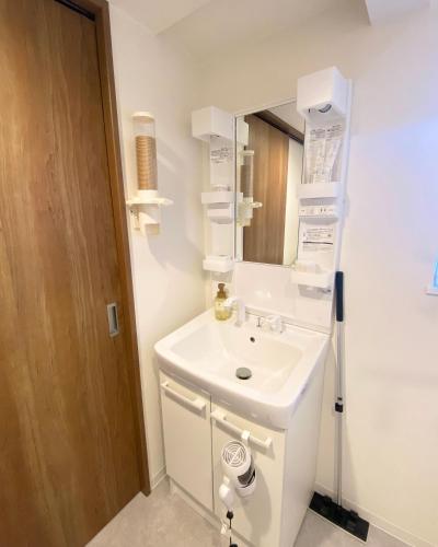 a bathroom with a white sink and a mirror at AJITO Hostel 別館2 in Shingū