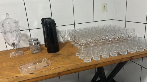 a bunch of glasses sitting on a wooden table at pousada irmãs in Pindamonhangaba