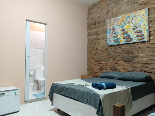 a bedroom with a bed and a stone wall at Origem Bahía in Salvador