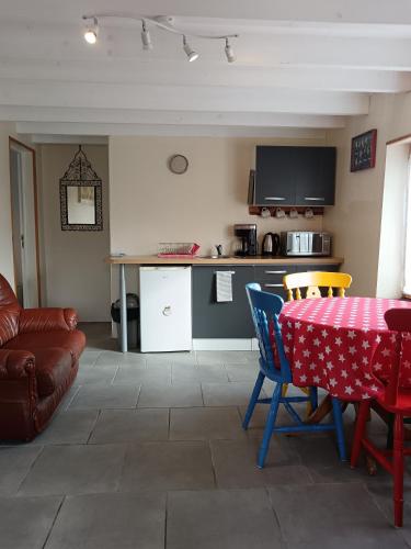 a living room with a table and a kitchen at Gîte FABEL HAUT in Durfort