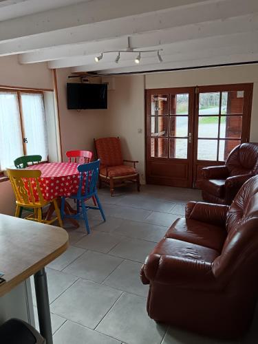 a living room with a couch and a table and chairs at Gîte FABEL HAUT in Durfort