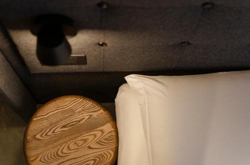 a close up of a bed with a white pillow and a wooden board at Dolomiten Apartments in Tesero