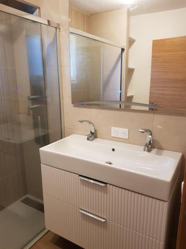 a bathroom with a white sink and a shower at Agréable maison bien située in Capbreton