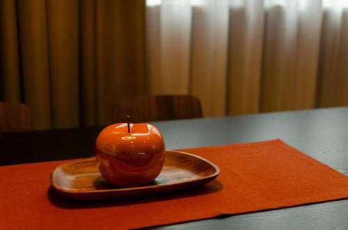 an orange apple sitting on a plate on a table at Dolomiten Apartments in Tesero