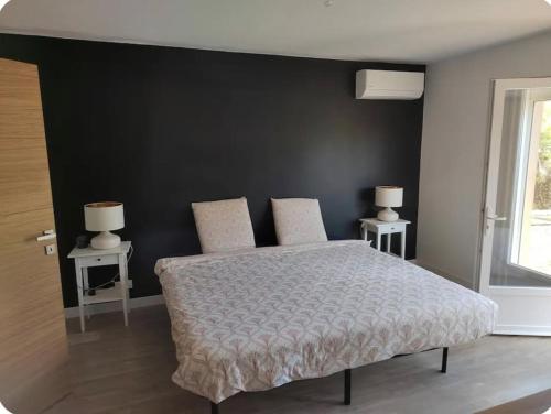 a bedroom with a bed with a black wall at Agréable maison bien située in Capbreton