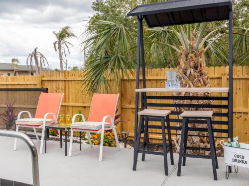 a patio with chairs and a table and umbrella at Englewood, Manasota Keys - 2 Bedroom Luxury Villa, Pool, Game room, 6 min to Beaches next to Canal in Englewood