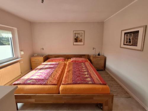 a bedroom with a large bed and a window at Ferienhäuschen blauer See in Bockhorn