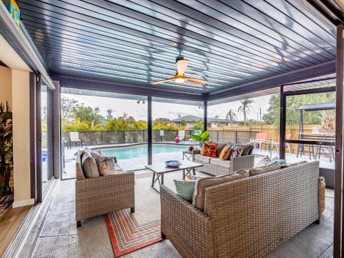 a screened in porch with couches and a pool at Englewood, Manasota Keys - 2 Bedroom Luxury Villa, Pool, Game room, 6 min to Beaches next to Canal in Englewood