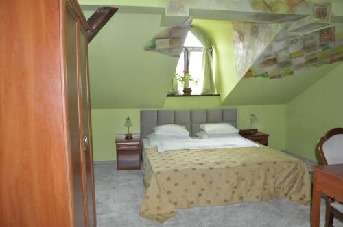 a bedroom with a bed with a green wall at Villa Del Arte Bed & Breakfast in Wadowice