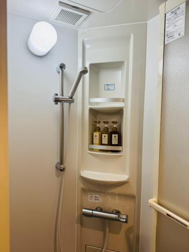 a bathroom with a refrigerator with bottles of alcohol at SnowMapleHouse西川口 in Kawaguchi