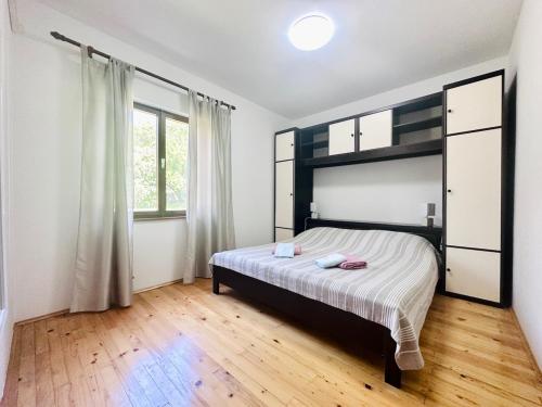 a bedroom with a bed and a large window at Kuća Sonja in Vranje