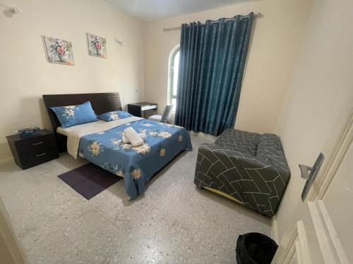 a bedroom with a bed and a chair in it at White house in Abu Dhabi