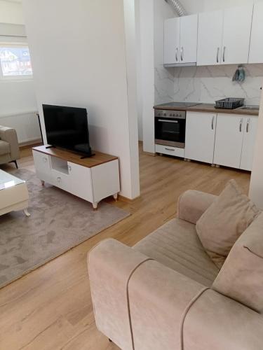 salon z kanapą i telewizorem w obiekcie Charisma Homes 3 w Prisztinie