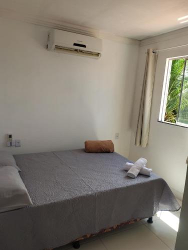 a bed in a white room with a window at Aconchego da Alegria!!! in Porto Seguro