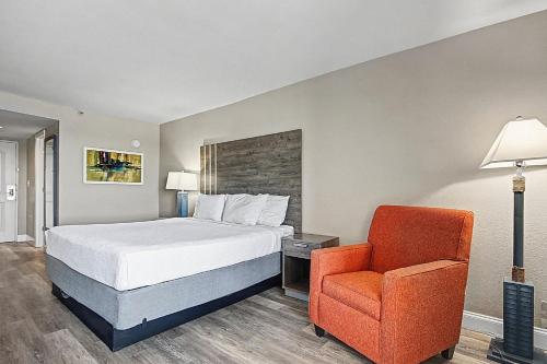 a hotel room with a bed and a chair at Carolinian Beach Resort in Myrtle Beach