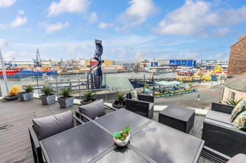 a table and chairs on a balcony with a marina at Harbours Edge - Front-Line Harbour Views in Poole
