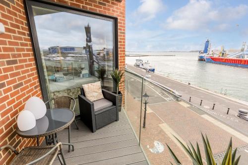 a balcony with a table and chairs and a view of the water at Harbours Edge - Front-Line Harbour Views in Poole