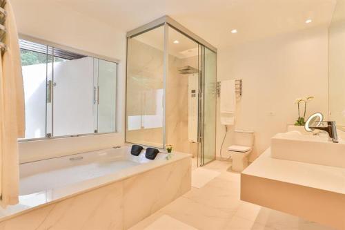 a bathroom with a tub and a toilet and a sink at Villa Casato Residenza Boutique in Campos do Jordão