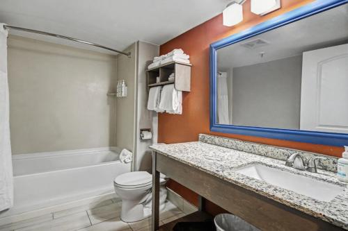 a bathroom with a sink and a toilet and a mirror at Carolinian Beach Resort in Myrtle Beach