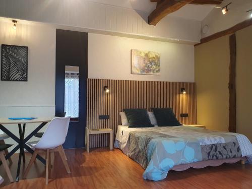 a bedroom with a bed and a desk and a table at Chambres d'Hôtes Grange Carrée in Saint-Rémy