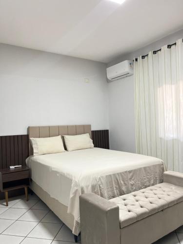 a white bedroom with a bed and a couch at Vista da Serra, Casa Térrea e Superior, entradas independentes in Cavalcante