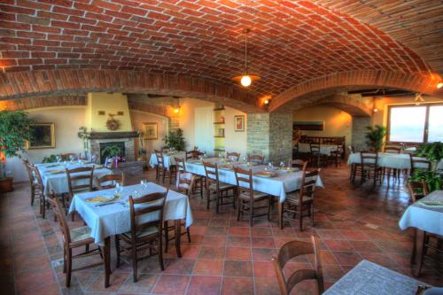 a restaurant with tables and chairs and a brick wall at Azienda Agrituristica Alcastlè in Montabone