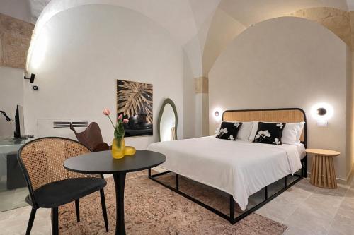 a bedroom with a bed and a table and chairs at CAVA Urban Relais & Pool in Lecce
