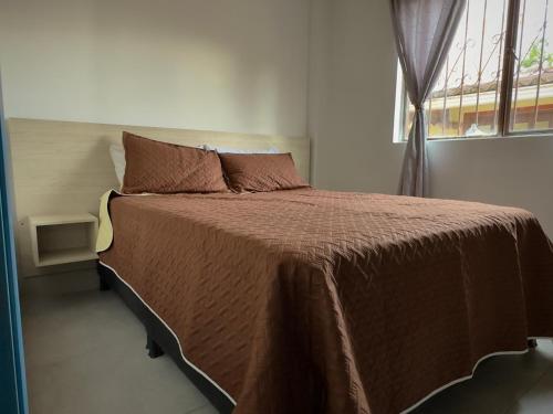 a bedroom with a large bed with a window at Hotel Casa La Macana in Macanal