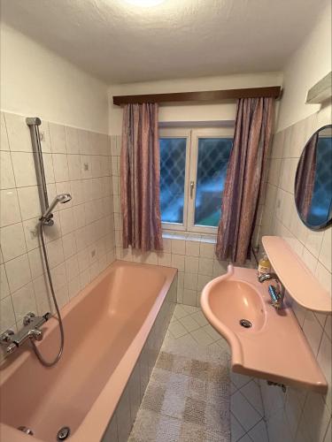 a bathroom with a pink tub and a sink at Ferienwohnung Wasserfall in Golling an der Salzach