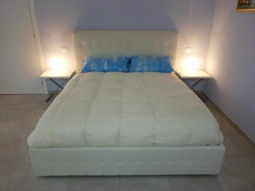 a large white bed in a room with two lamps at La Casa Dei Nonni in Felegara