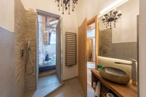 ein Badezimmer mit Waschbecken und Dusche mit Badewanne in der Unterkunft Hotel Faloria in Moena