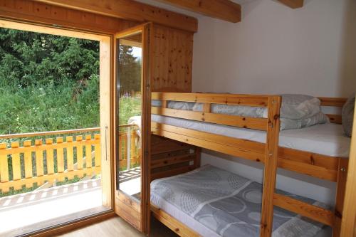 a couple of bunk beds in a room with a window at Chalet Ski in&out in Les Collons