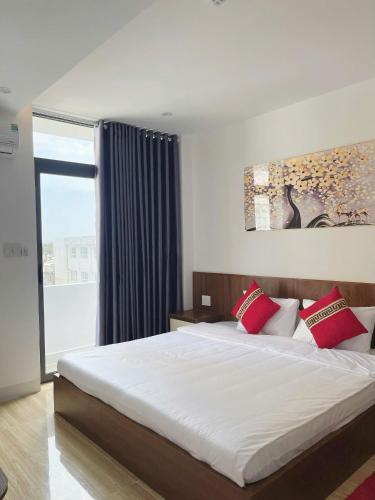 a bedroom with a large bed with red pillows at Phao Hotel in Vung Tau