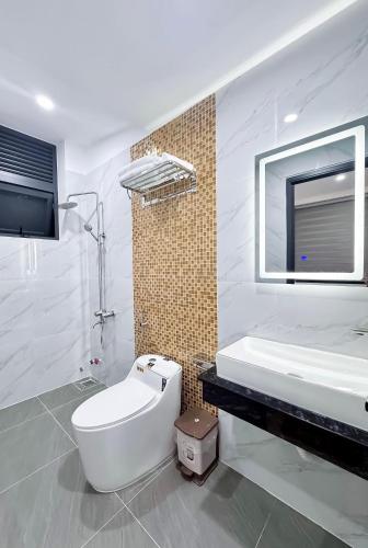 a bathroom with a toilet and a sink and a mirror at Phao Hotel in Vung Tau