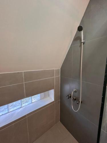 a shower stall in a bathroom with a window at Selah Cabaña de dos habitaciones in Villa Las Rosas
