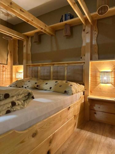 a bedroom with a large wooden bed with wooden shelves at Edenski vrt in Ivančna Gorica