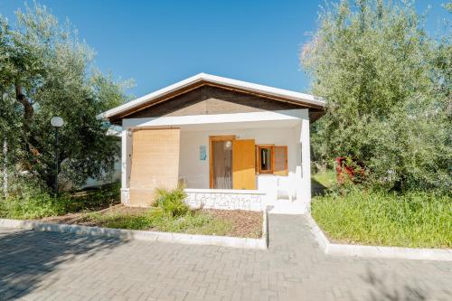 ein kleines Haus mit einer Tür in einem Hof in der Unterkunft Centro Vacanze Oriente in Vieste