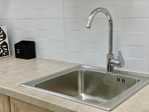 eine Küchenspüle mit Wasserhahn auf einer Arbeitsplatte in der Unterkunft Citrus in Athen