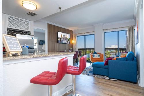 a living room with a bar with red chairs at Lakeview 2 suites 6 min to New EPIC Universe in Orlando