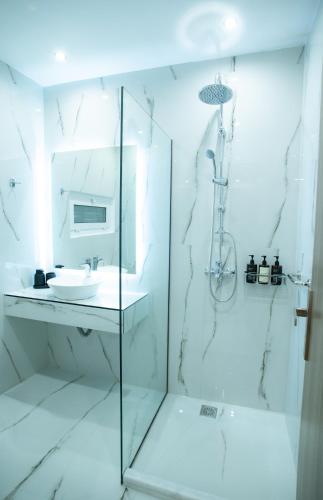 a white bathroom with a sink and a shower at Klitiou 7 Boutique Hotel in Athens